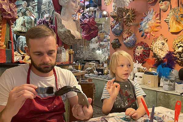 man and boy making a venetian mask